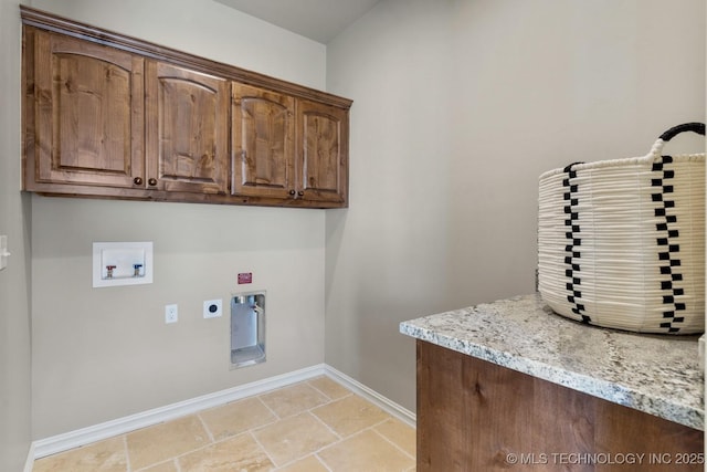 laundry area with hookup for an electric dryer, washer hookup, baseboards, cabinet space, and stone finish flooring