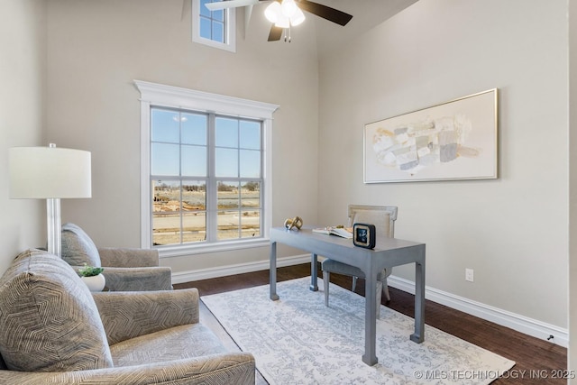 office area with ceiling fan, baseboards, and dark wood-type flooring