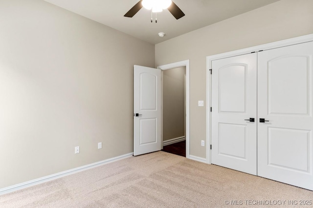 unfurnished bedroom with light carpet, a ceiling fan, baseboards, and a closet