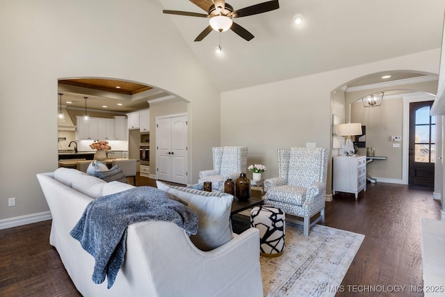 living area with baseboards, crown molding, arched walkways, and dark wood-type flooring