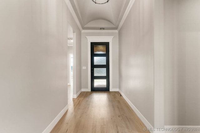 entryway with light hardwood / wood-style flooring, crown molding, and vaulted ceiling