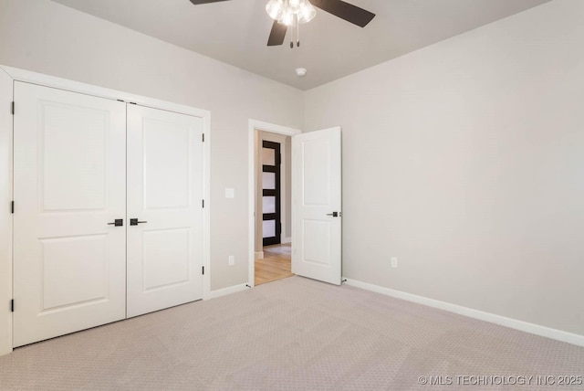 unfurnished bedroom with light carpet, ceiling fan, baseboards, and a closet