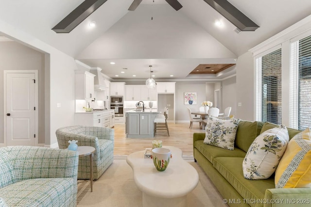 living room with baseboards, ceiling fan, light wood-type flooring, high vaulted ceiling, and recessed lighting