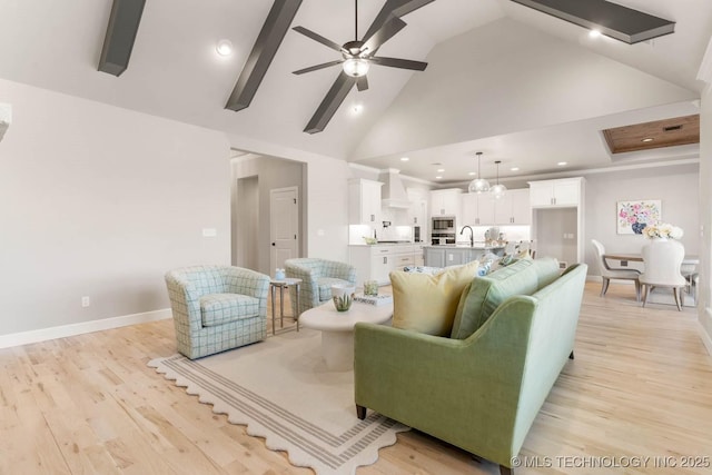 living area featuring high vaulted ceiling, a ceiling fan, baseboards, light wood-style floors, and beam ceiling