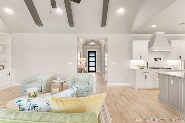 living area with baseboards, a ceiling fan, ornamental molding, vaulted ceiling with beams, and light wood-style floors