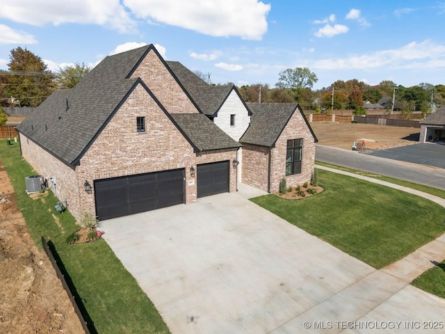 french country inspired facade featuring brick siding, a shingled roof, concrete driveway, an attached garage, and a front yard