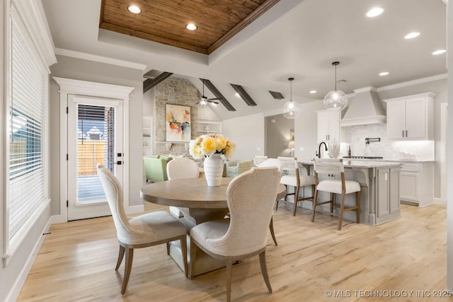 dining area with wood ceiling, a ceiling fan, ornamental molding, light wood-type flooring, and a raised ceiling