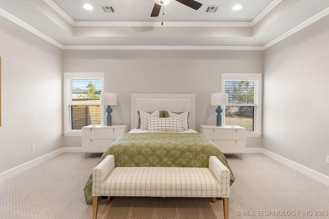 carpeted bedroom featuring a tray ceiling, visible vents, and multiple windows