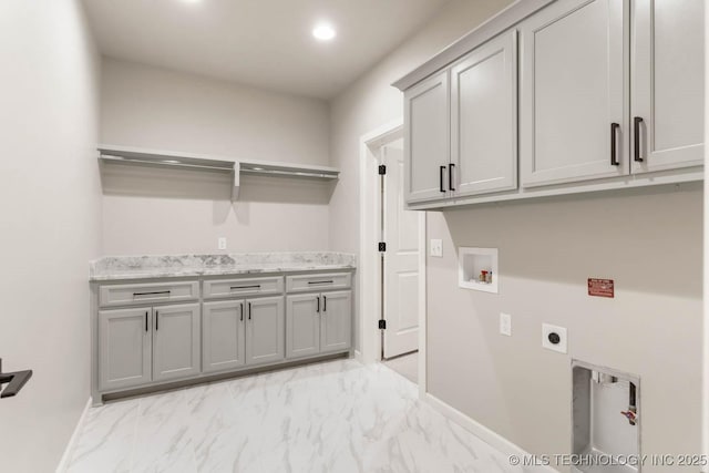 laundry room featuring hookup for an electric dryer, washer hookup, baseboards, marble finish floor, and cabinet space