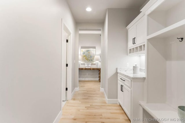 hall with recessed lighting, light wood-style flooring, and baseboards