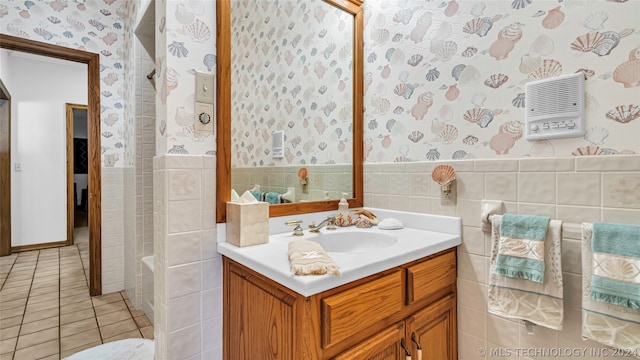 bathroom with tile floors, tile walls,  shower combination, tasteful backsplash, and vanity