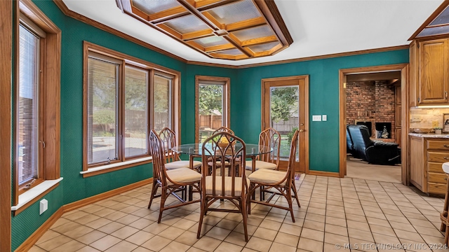 dining space featuring ornamental molding, light tile floors, brick wall, and a brick fireplace