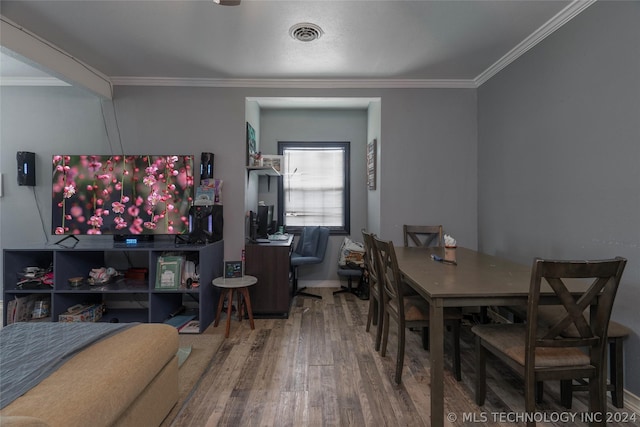 dining space featuring crown molding and hardwood / wood-style flooring