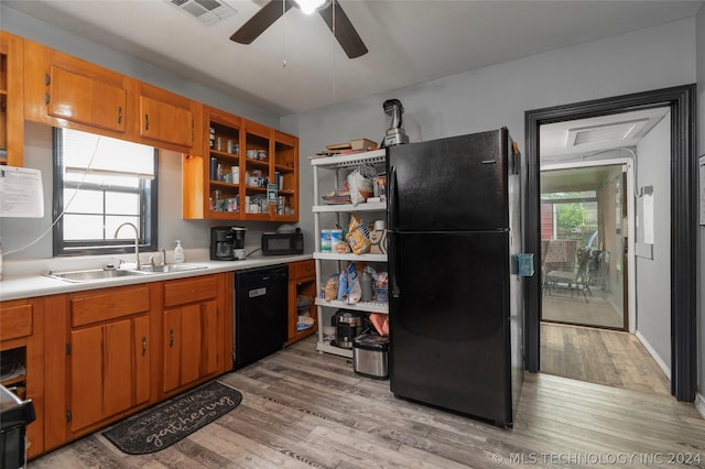 kitchen with light hardwood / wood-style floors, sink, a wealth of natural light, and black appliances