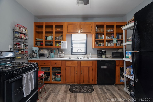 kitchen with sink, hardwood / wood-style floors, and black appliances