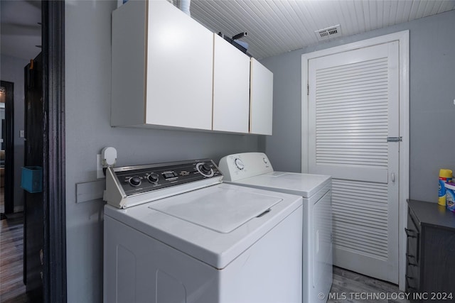 laundry area featuring cabinets, washer and clothes dryer, and dark hardwood / wood-style floors