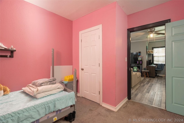 carpeted bedroom with ceiling fan and ornamental molding