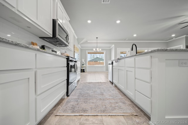 kitchen featuring a chandelier, ornamental molding, white cabinets, light tile floors, and pendant lighting