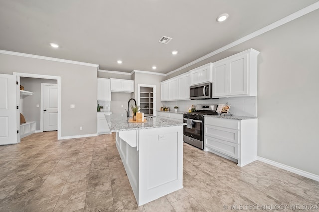 kitchen featuring white cabinets, a kitchen island with sink, light tile floors, and appliances with stainless steel finishes