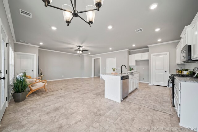 kitchen featuring white cabinetry, ceiling fan with notable chandelier, appliances with stainless steel finishes, an island with sink, and light tile floors