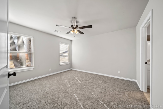 empty room with plenty of natural light, ceiling fan, and carpet flooring