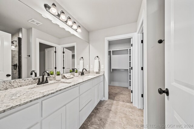 bathroom featuring a shower with door, tile floors, large vanity, and double sink