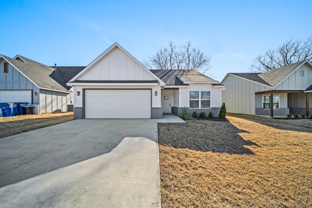 view of front of house with a front yard, a garage, and central AC unit