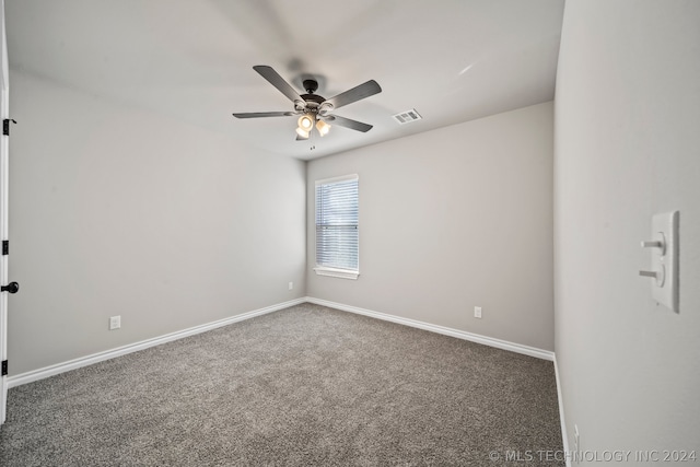 unfurnished room featuring ceiling fan and dark colored carpet