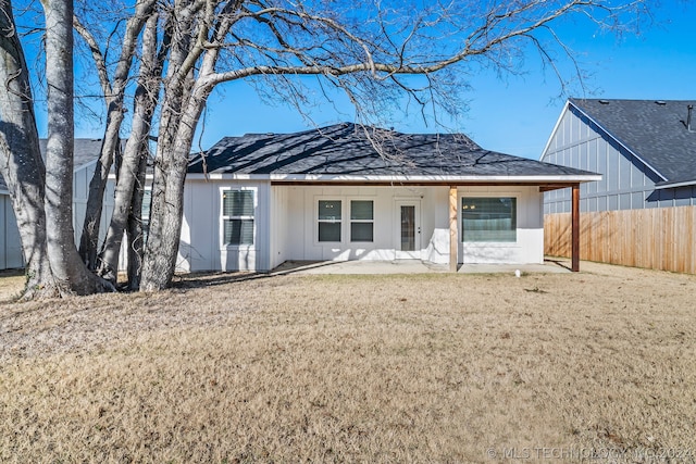 back of property with a lawn and a patio area