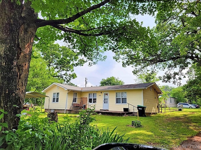 rear view of house featuring a yard and a carport