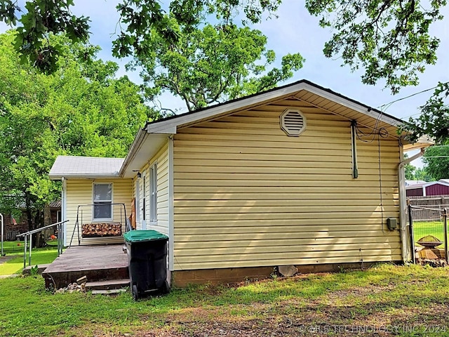 view of side of property with a lawn and a deck