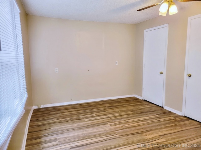 unfurnished bedroom with a textured ceiling, light hardwood / wood-style flooring, and ceiling fan