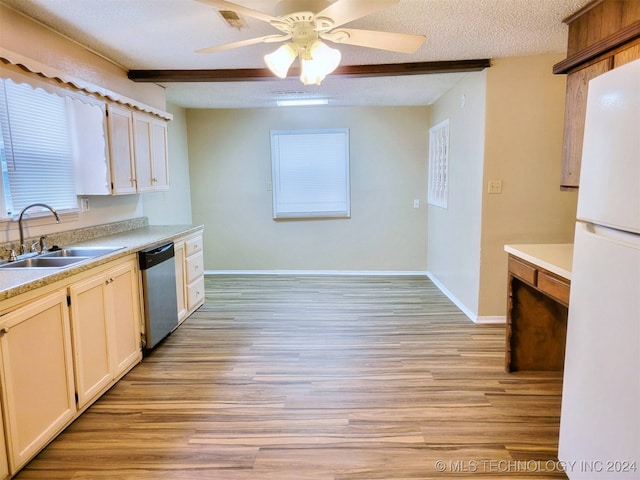 kitchen with dishwasher, sink, beamed ceiling, white fridge, and a textured ceiling