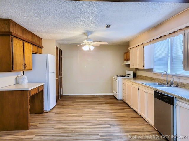 kitchen featuring ceiling fan, sink, light hardwood / wood-style flooring, a textured ceiling, and white appliances