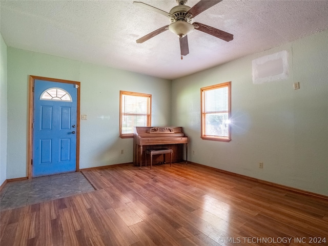 foyer entrance with hardwood / wood-style flooring, ceiling fan, and a textured ceiling