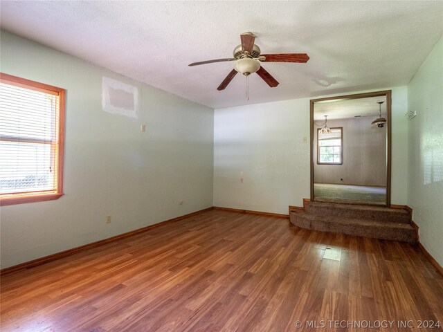 interior space with hardwood / wood-style floors, ceiling fan, and a textured ceiling