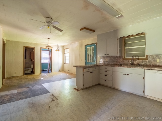 kitchen with tasteful backsplash, white dishwasher, white cabinets, sink, and pendant lighting