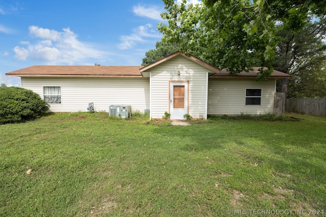 rear view of property featuring a yard