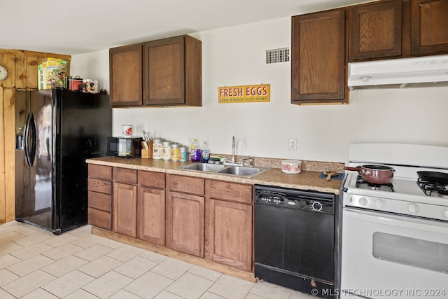 kitchen featuring sink, black appliances, and light tile floors