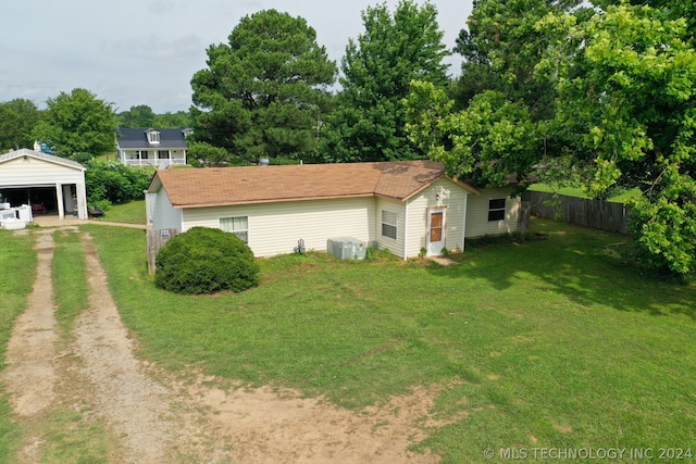 exterior space featuring central AC unit and a lawn