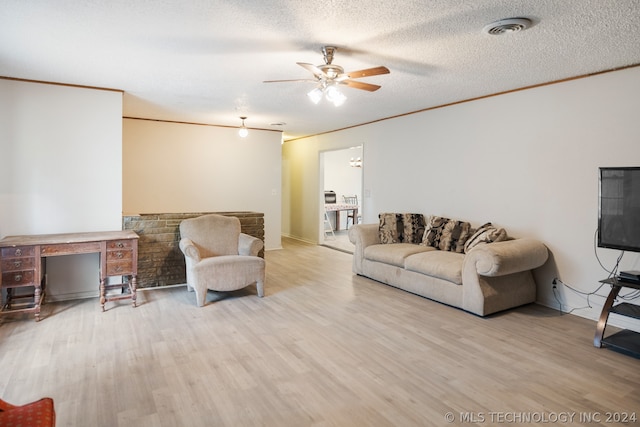 living room featuring hardwood / wood-style flooring, ceiling fan, and a textured ceiling