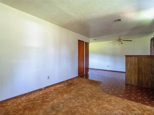 carpeted empty room with a textured ceiling and ceiling fan