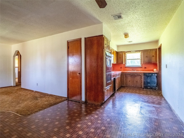 kitchen featuring a textured ceiling, sink, and ceiling fan