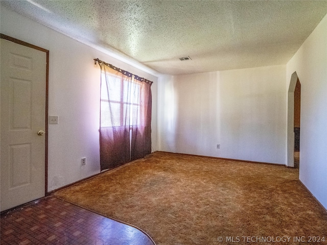 spare room featuring a textured ceiling and carpet floors