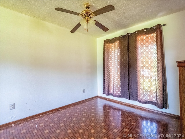 spare room with a textured ceiling and ceiling fan