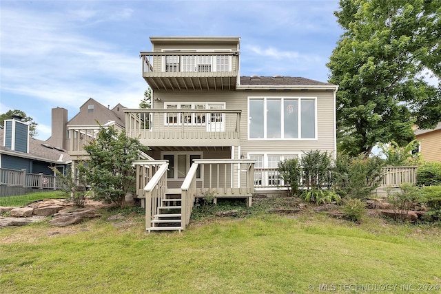 back of property featuring a yard, a balcony, and a deck