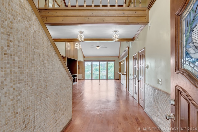 hall featuring wood-type flooring, ornamental molding, and tile walls