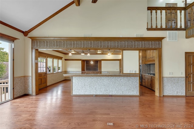 unfurnished living room featuring light hardwood / wood-style floors, high vaulted ceiling, and a wealth of natural light