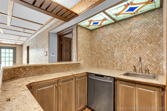 kitchen featuring dishwasher, decorative backsplash, and sink