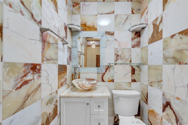 bathroom featuring vanity, toilet, and tile walls